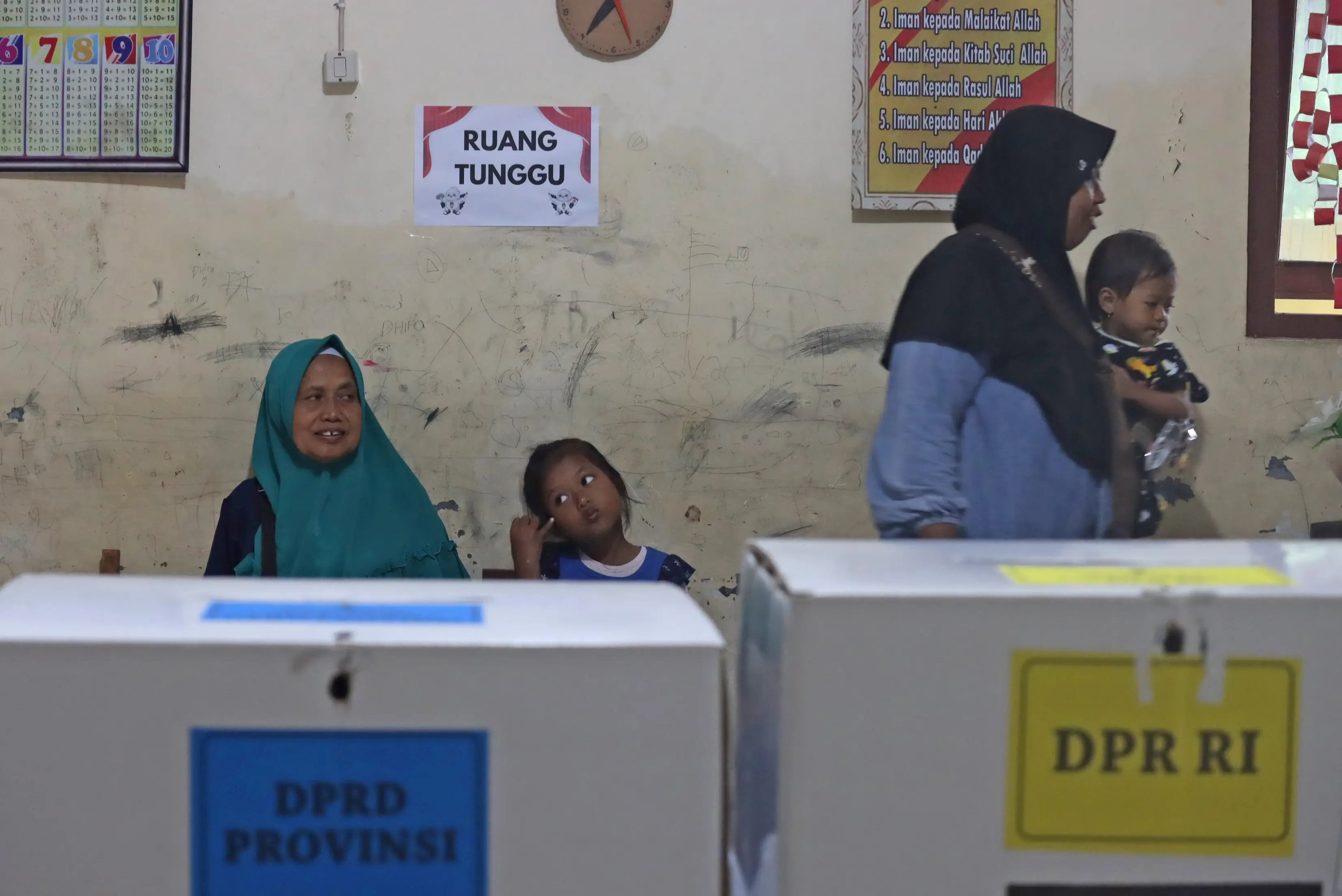 Warga sedang menunggu untuk dipanggil oleh petugas KPPS guna melakukan pencoblosan di bilik suara, pada Pemilu susulan, di Desa Wonorejo, Kecamatan Karanganyar, Kabupaten Demak, Sabtu (24/2).